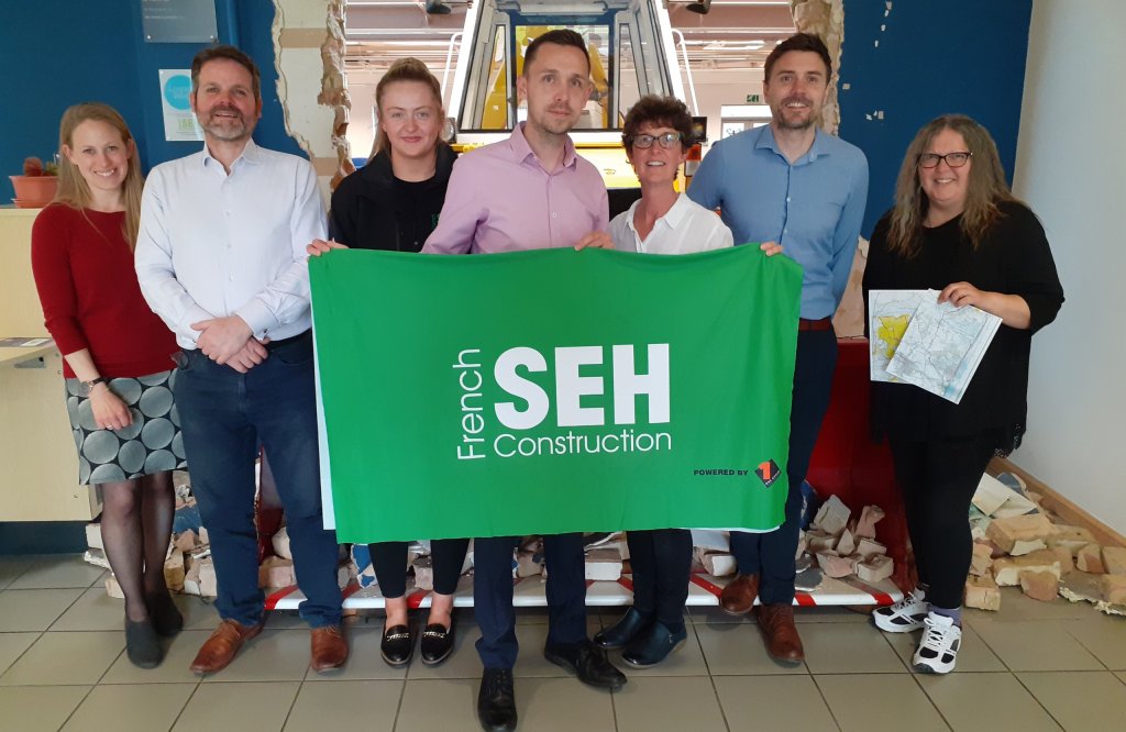 SEH French Alzheimer's Society charity walk team standing together with SEH French banner.