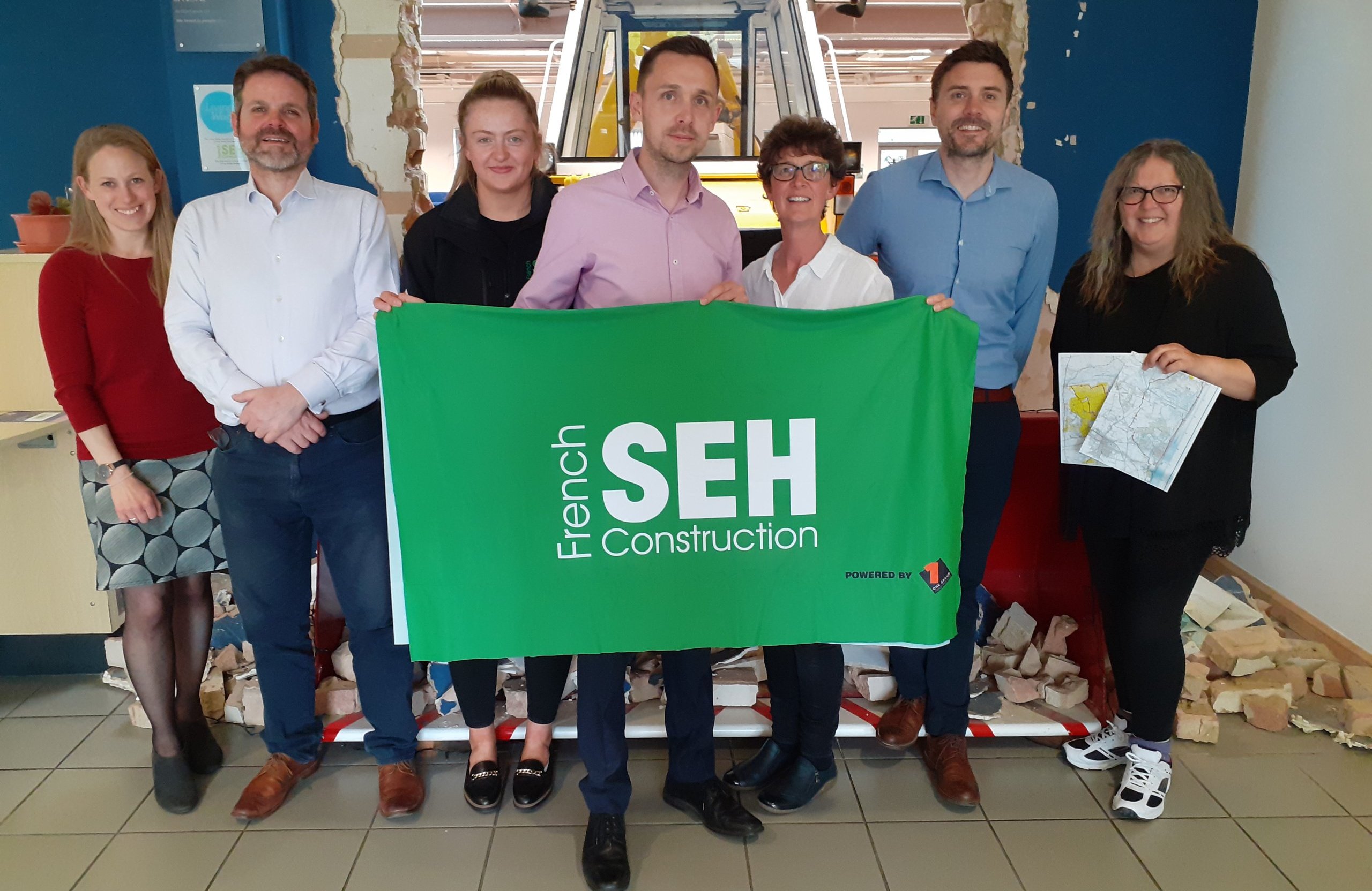 SEH French Alzheimer's Society charity walk team standing together with SEH French banner.